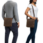 Brown vertical leather shoulder bag on man and woman worn crossbody and at the side