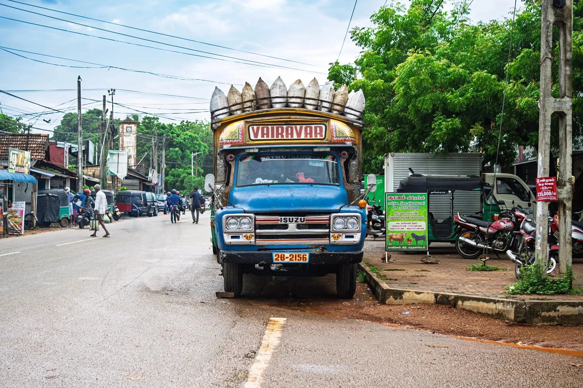 Bunt bemalter Lastwagen mit Säcken auf einer Straße in Jaffna im Norden Sri Lankas - MrCOLOMBO Reportage aus dem tamilischen Norden